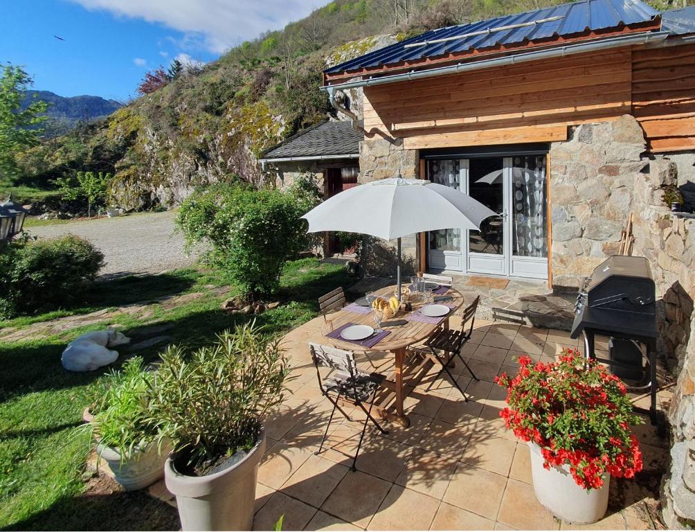 a patio with a table and an umbrella in front of a building at Chalet en Castel in Ax-les-Thermes