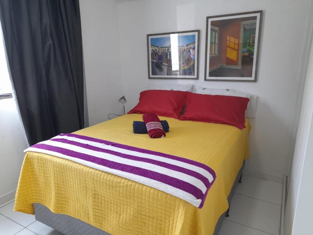 - une chambre avec un lit jaune et 2 oreillers rouges dans l'établissement Apartamento com piscina, à Récife