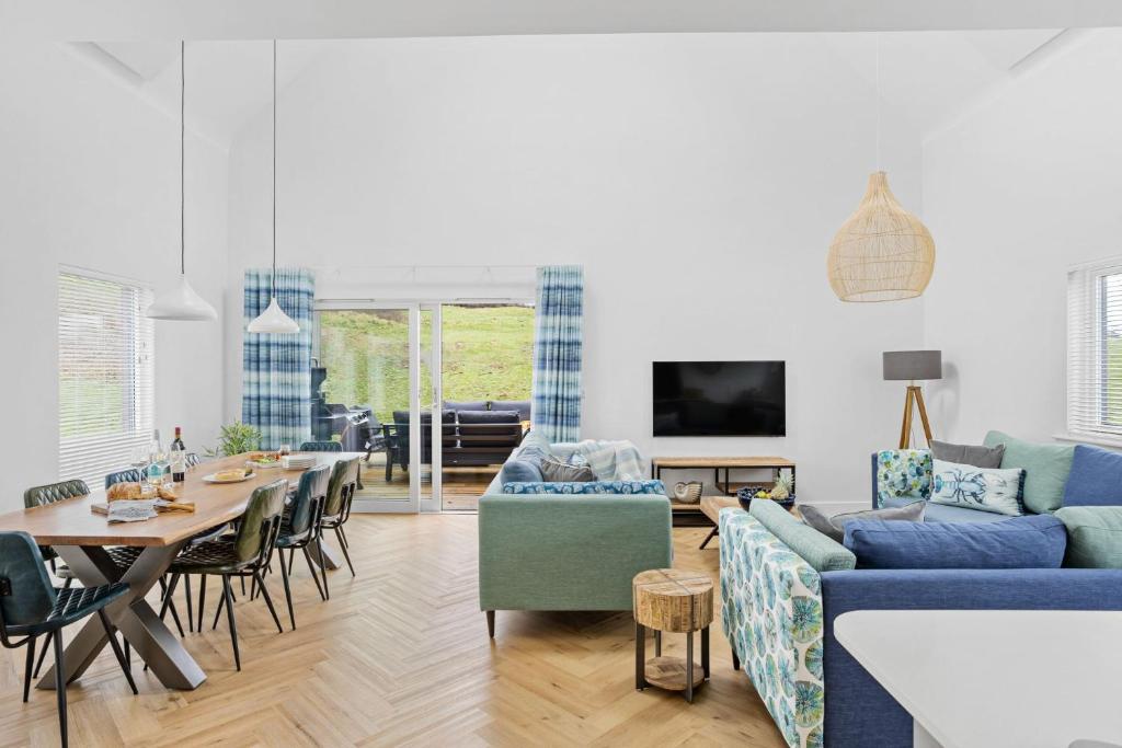 a living room with a blue couch and a table at No 9 The Vista, Willingcott, Woolacombe in Woolacombe