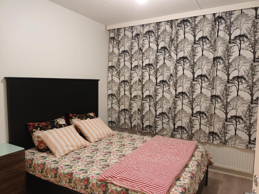 a bedroom with a bed with a patterned wall at Centrally Located Studio Apartment in Espoo