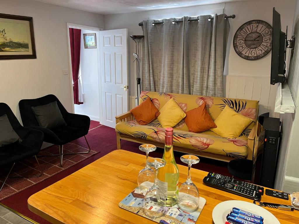 - un salon avec un canapé et une table avec des verres à vin dans l'établissement Seaview Cottage 24 Freeman Street, à Wells-next-the-Sea