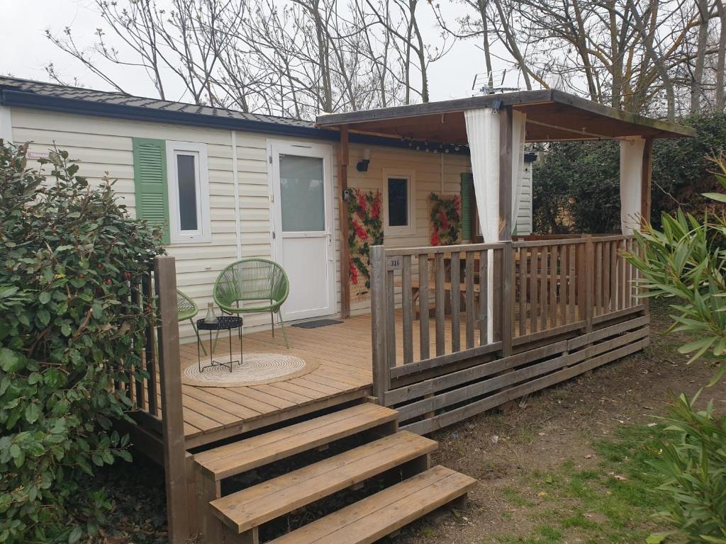 a house with a wooden deck with a gazebo at Camping Domaine des Iscles in La Roque-dʼAnthéron