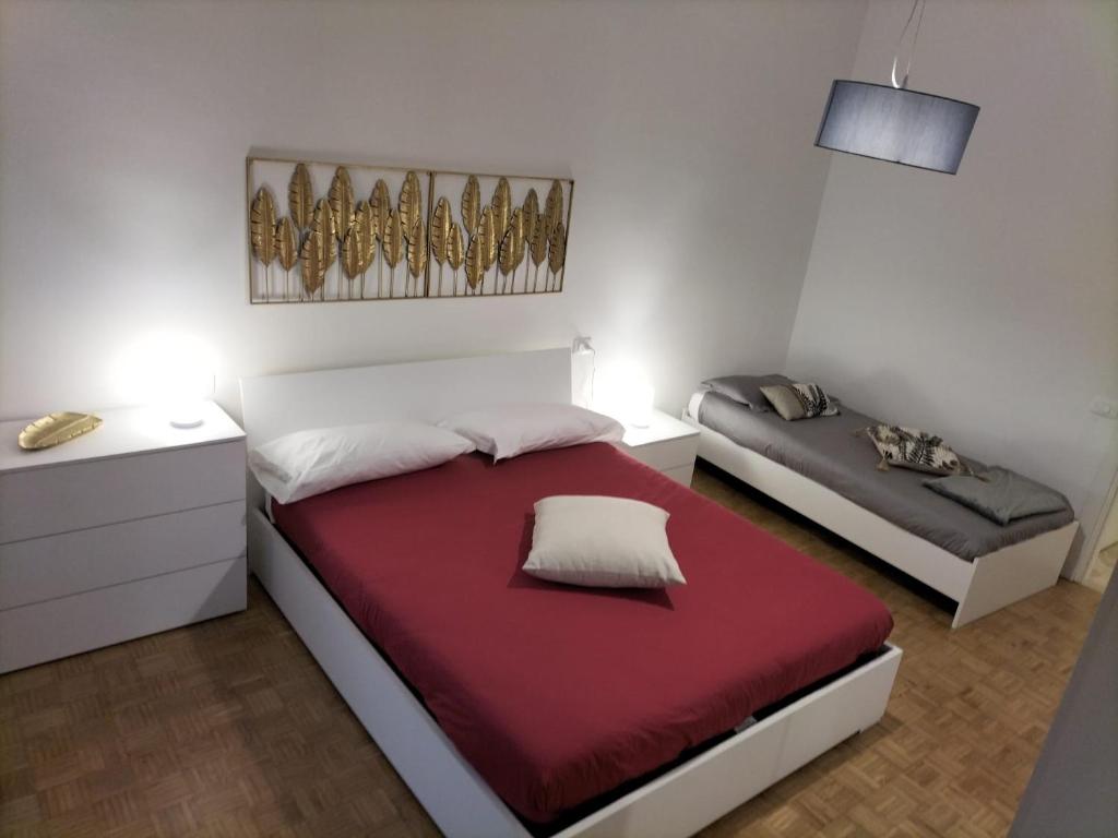 sypialnia z 2 łóżkami i czerwonym kocem w obiekcie Borgo 90 Bergamo house w Bergamo