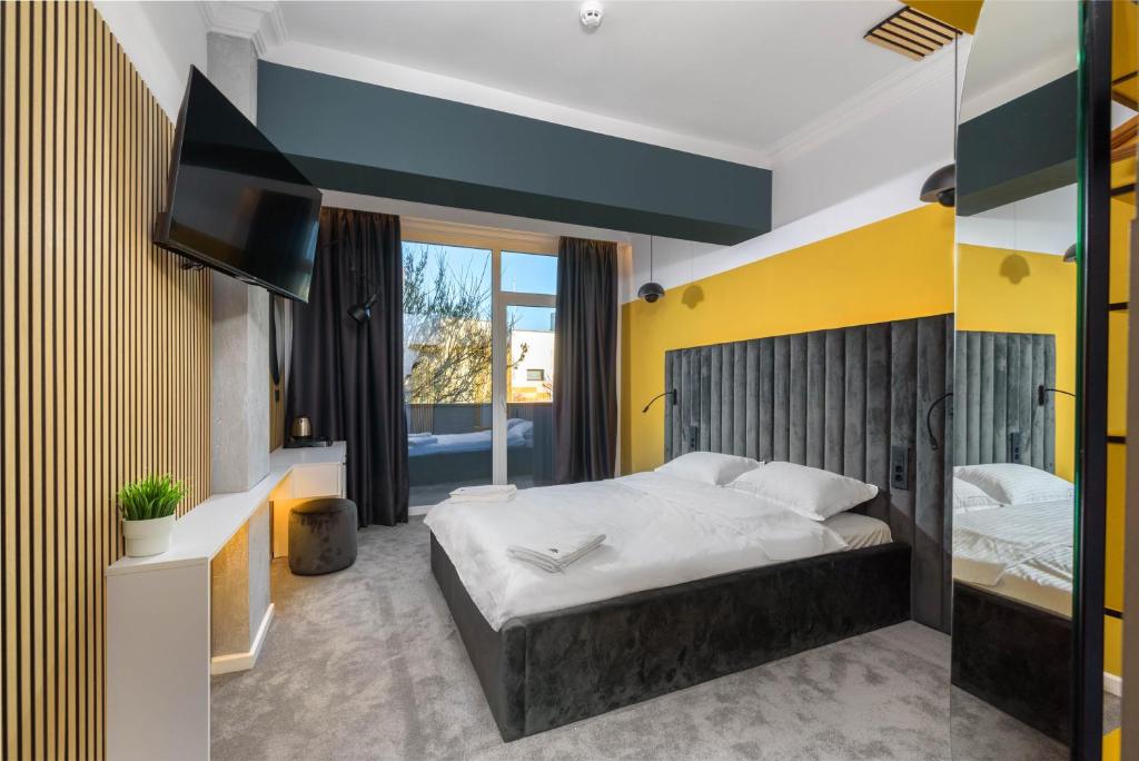 a bedroom with a large bed and a yellow wall at URBAN BUDGET HOTEL in Timişoara