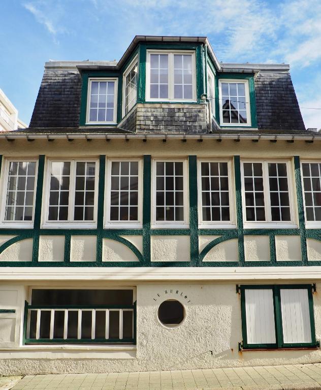 un grand bâtiment vert et blanc avec fenêtres dans l'établissement Le Hublot, à Le Touquet-Paris-Plage