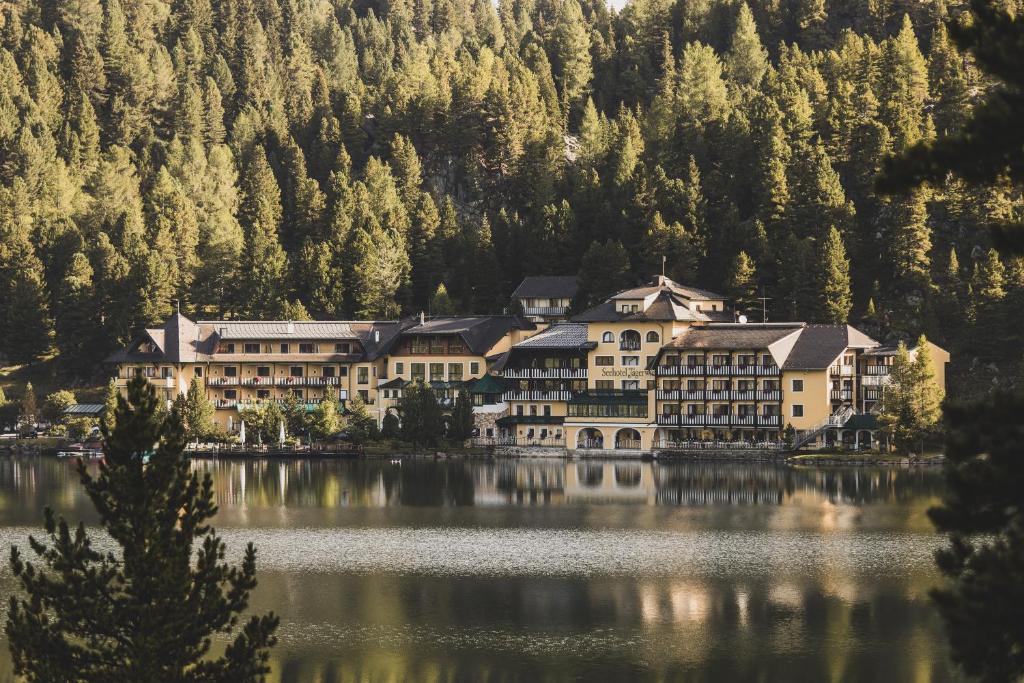 un complejo en un lago frente a una montaña en Seehotel Jägerwirt, en Turracher Höhe