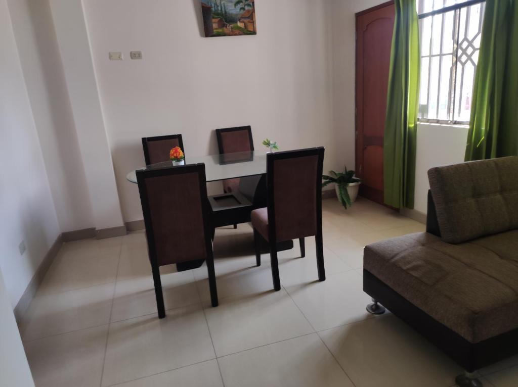 a living room with a table with chairs and a couch at Apartamento Vallejo in Trujillo