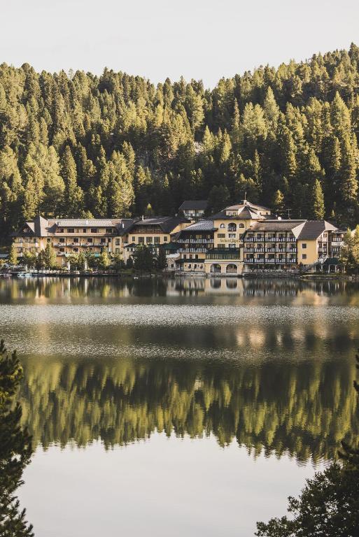 a group of buildings on the shore of a lake at Seehotel Jägerwirt in Turracher Hohe