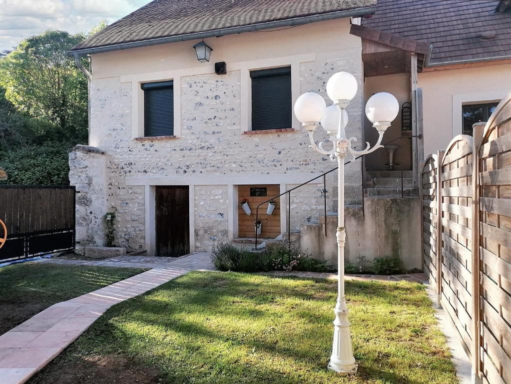 un lampione bianco di fronte a una casa di Maison de 2 chambres avec jardin clos et wifi a Sainte Genevieve les Gasny a Sainte-Geneviève-lès-Gasny