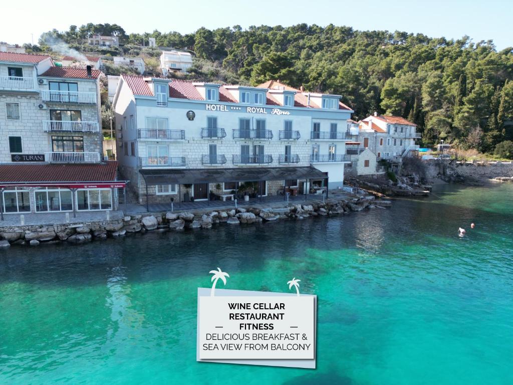 a sign in the water next to a river with buildings at Hotel ROYAL RINA in Stomorska