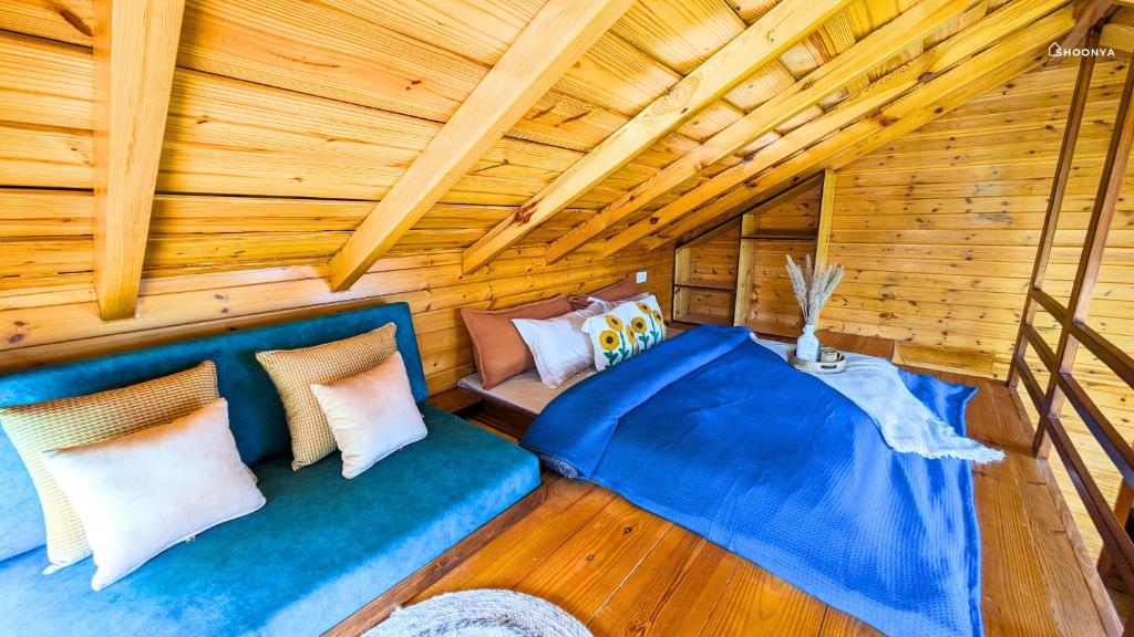 a room with a blue couch in a log cabin at Shoonya Mukteshwar in Mukteswar