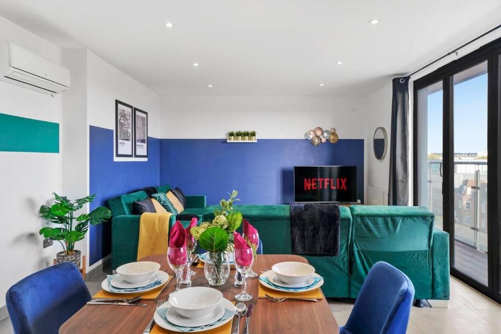 - un salon avec une table et un canapé vert dans l'établissement Stylish Gem Of Chelmsford with Balcony, à Chelmsford