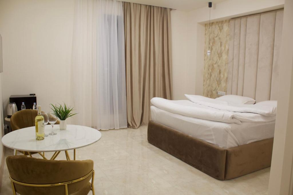 a bedroom with a large bed and a table at Lux Plaza Hotel in Arbatʼ