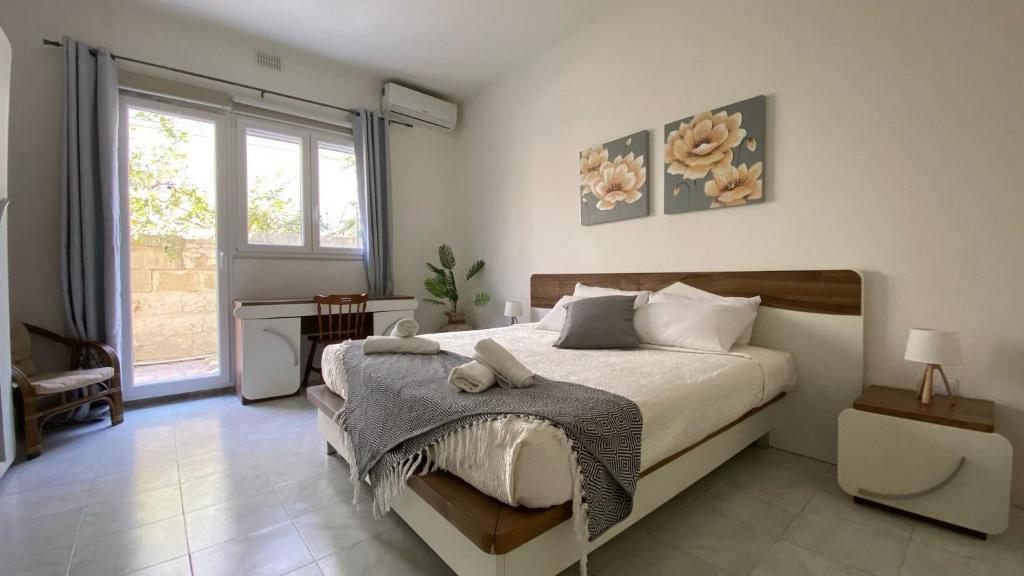 um quarto com uma cama e uma grande janela em Bright and spacious Double Room, shared bathroom em Tal-Għoqod
