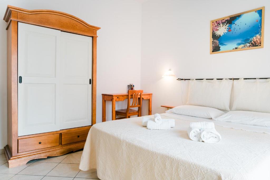 1 dormitorio con 1 cama con toallas en La Marmora en Alguer