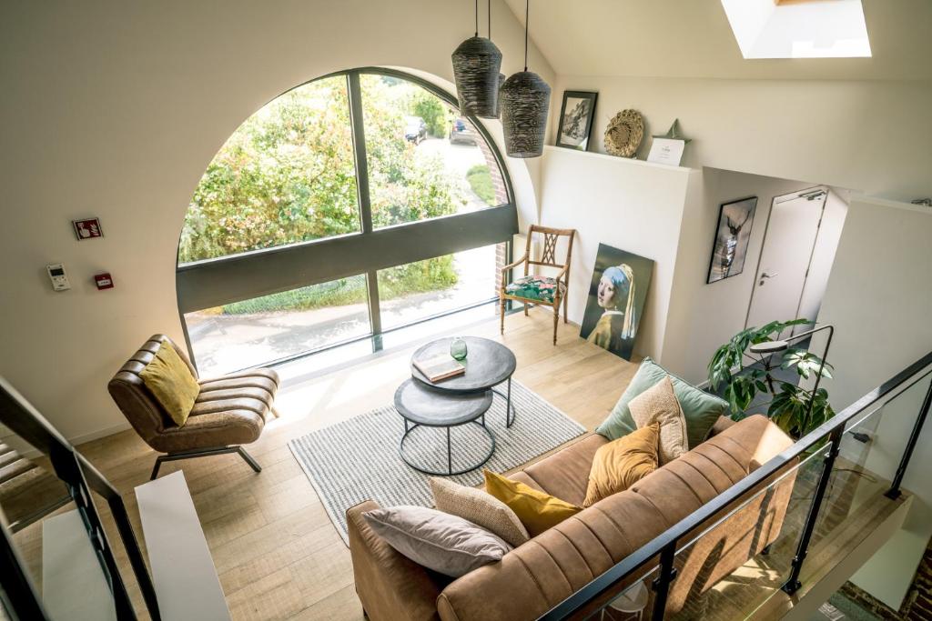 - un salon avec un canapé et une table dans l'établissement Vakantiewoning De Woestijn, à Roosdaal