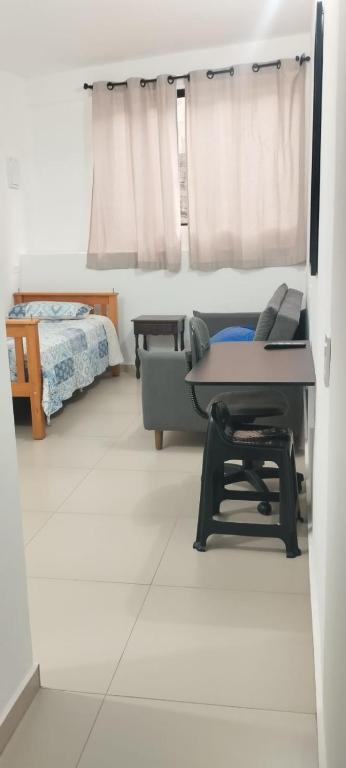 a living room with a table and a bed at Pousada da Vila 1 in Araçariguama