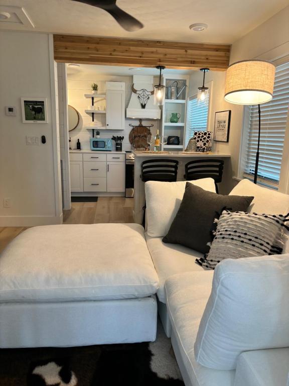 a living room with a white couch and a kitchen at Cracker Cow Cottages - Cottage B in Fort Myers