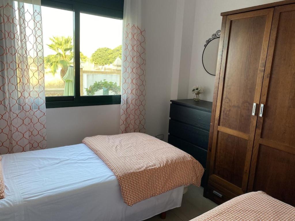 1 Schlafzimmer mit 2 Betten, einer Kommode und einem Fenster in der Unterkunft Prestigious Dona Pepa 2 Urbanisation with Shared Pool in Ciudad Quesada
