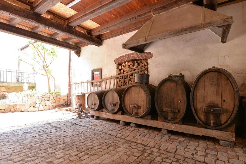 a row of wooden wine barrels in a room at Belle Maison Alsacienne de 1610 in Gueberschwihr