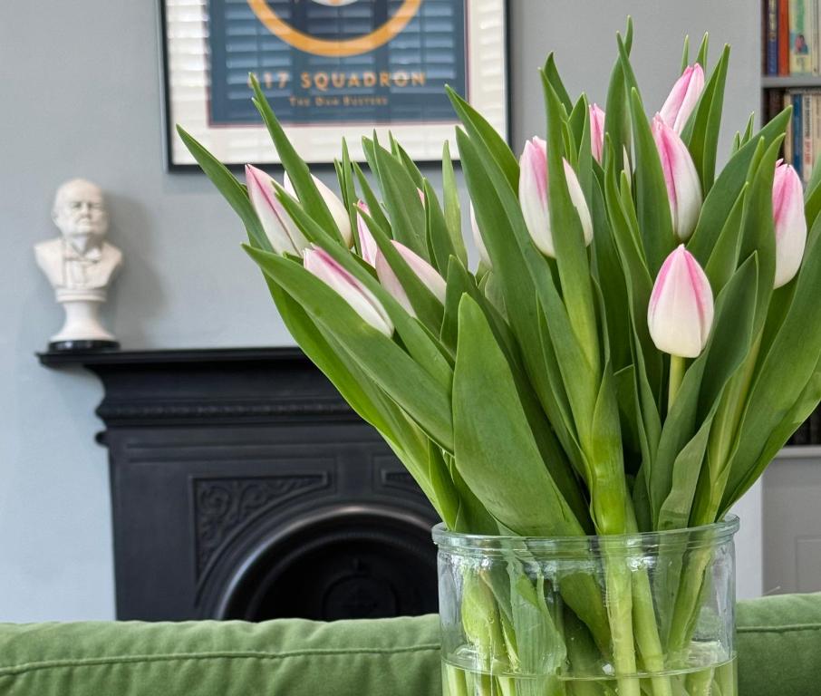 a vase filled with pink flowers sitting on a couch at Glenesk No 1 , Woodhall Spa in Lincolnshire