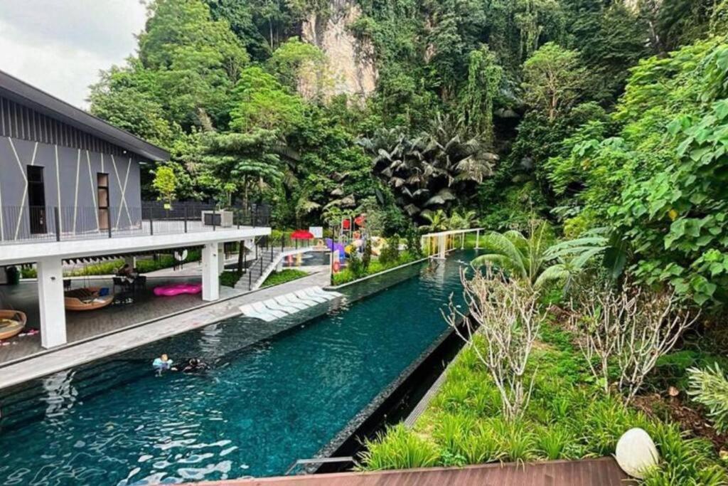 a river in front of a building with a bridge at Modern Lux Suite, The Cove Hillside Residence in Ipoh