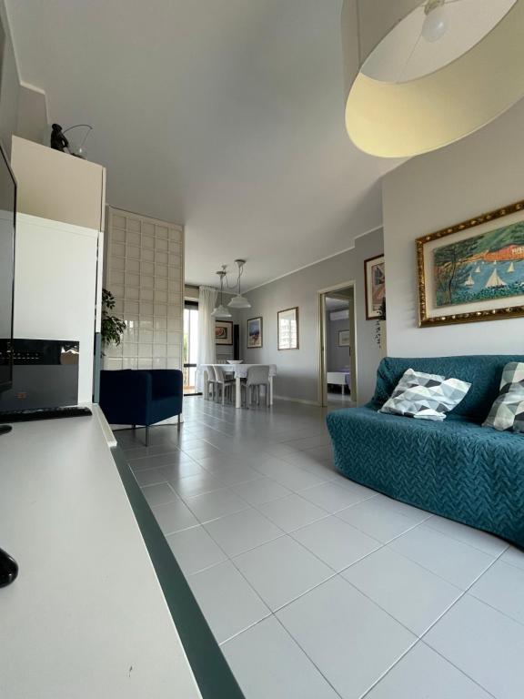 ein Wohnzimmer mit einem blauen Sofa und einem Tisch in der Unterkunft L'Arciunesa in Riccione