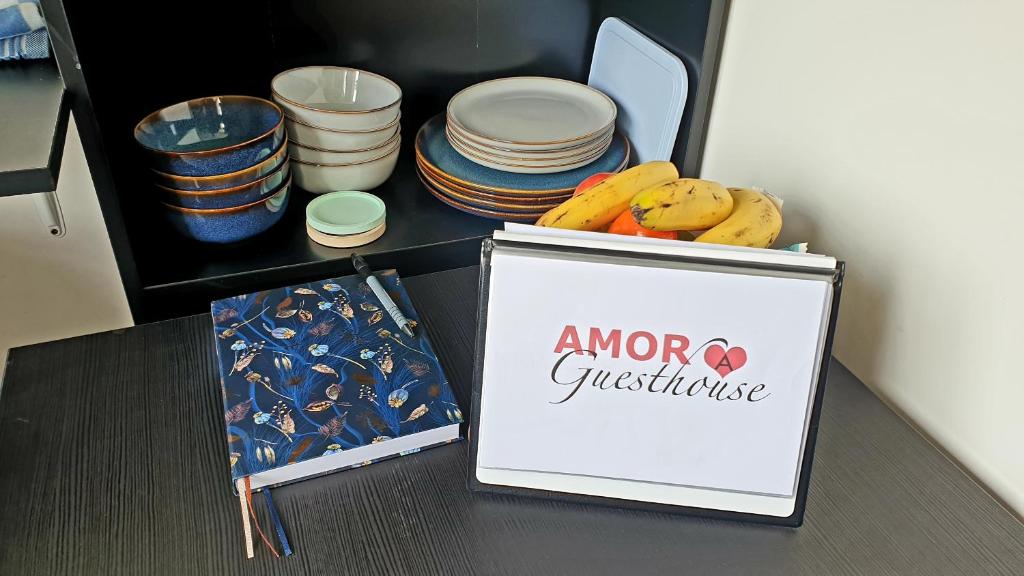 ein Schild auf einem Tisch mit einer Gruppe von Platten in der Unterkunft Amor Guesthouse in Amsterdam