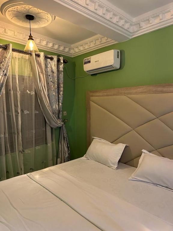 um quarto com uma cama com uma parede verde em CHAMBRE em Douala