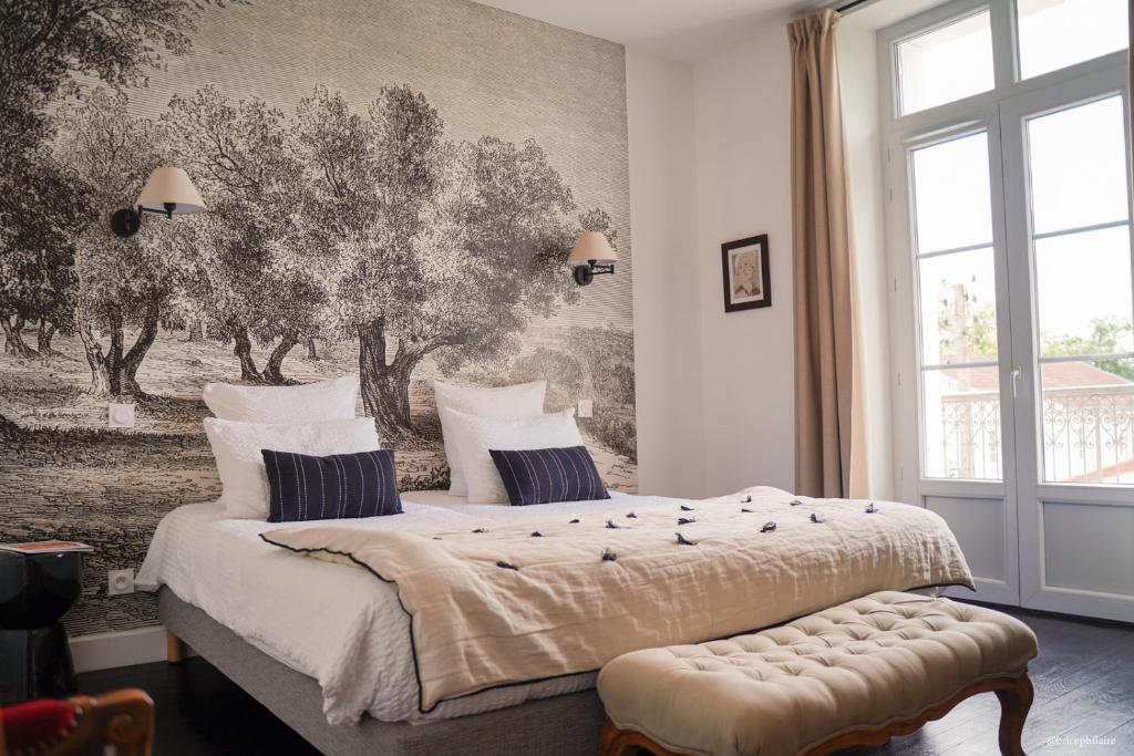 a bedroom with two beds and a wall mural at La Villa Marguerite in Périgueux