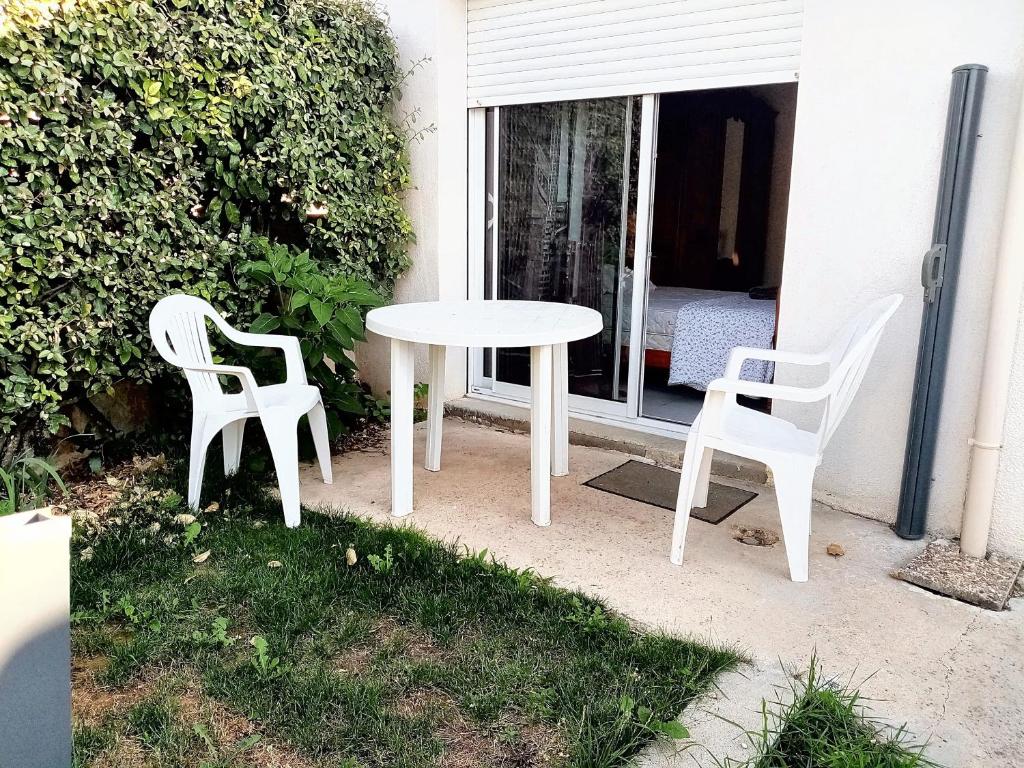 two chairs and a white table and chairs on a patio at Maison d'une chambre avec jardin clos et wifi a Tonnay Charente in Tonnay-Charente