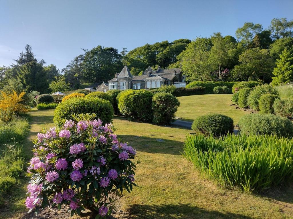 una casa con un jardín con flores púrpuras en 3 Bed in Near and Far Sawrey LLH24, en Far Sawrey