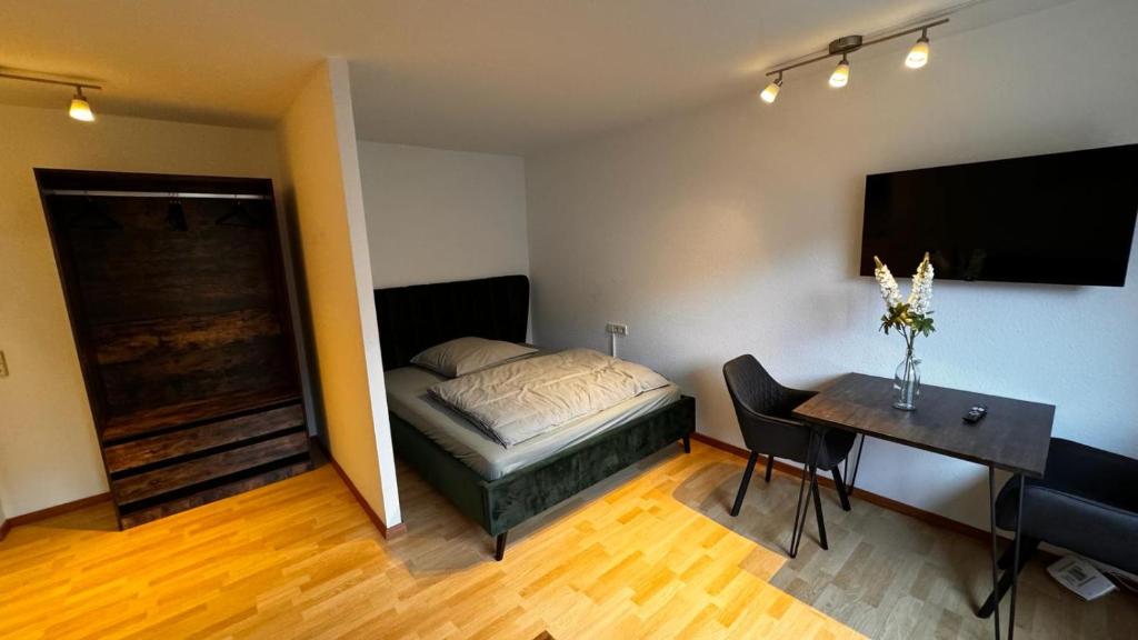Schlafzimmer mit einem Bett, einem Tisch und einem Schreibtisch in der Unterkunft Apartment 1 im Lehenviertel in Stuttgart