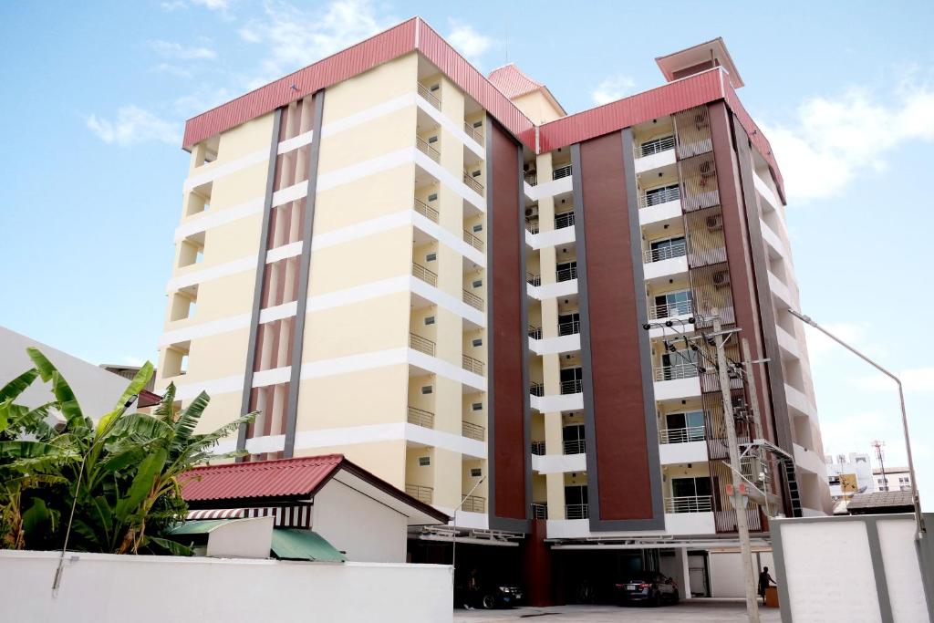 een hoog appartementencomplex met een rood dak bij 42 Place in Bangkok