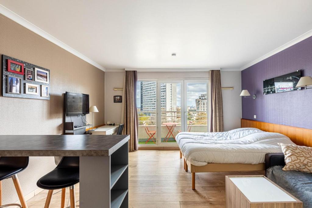 a bedroom with a bed and a couch and a table at GuestReady - Charming Stay near La Défense in Courbevoie