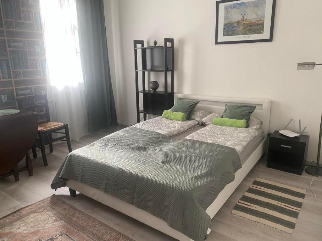 una camera da letto con un grande letto con cuscini verdi di Nette Wohnung in der Altstadt a Cheb