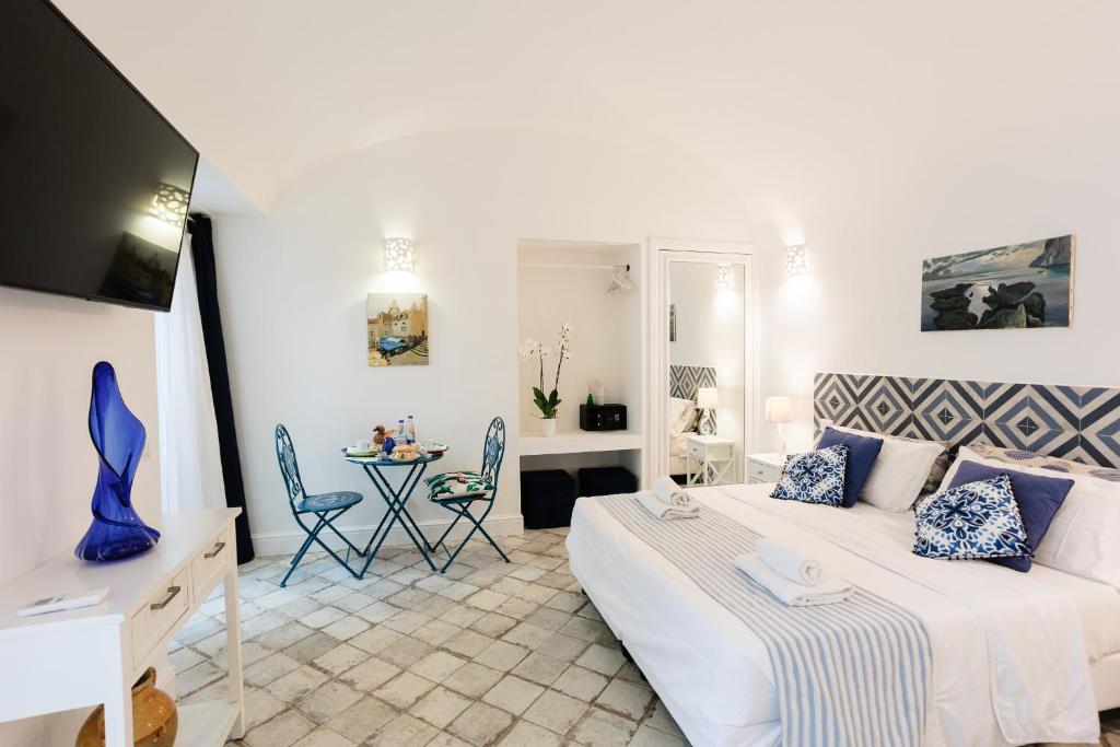 a bedroom with a bed and a table with chairs at MAISON SAINT MICHAEL in Capri