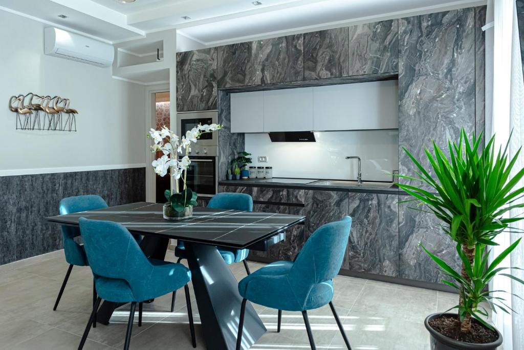 uma sala de jantar com uma mesa preta e cadeiras azuis em Il Narciso em Roma