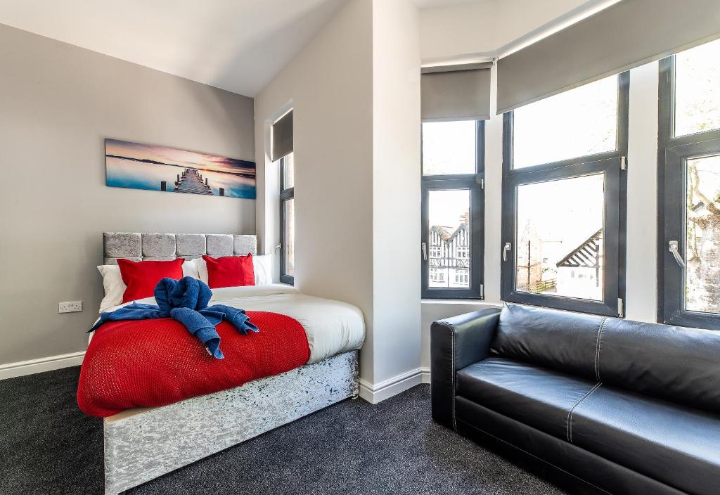- une chambre avec un lit doté d'oreillers rouges et d'un canapé dans l'établissement Stay Sleep Rest - Derby Road, à Nottingham