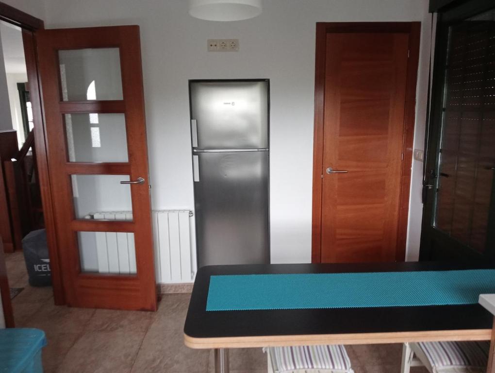 - une cuisine avec un réfrigérateur et une table dans la chambre dans l'établissement A EIRA DE ESTHER, à Teo
