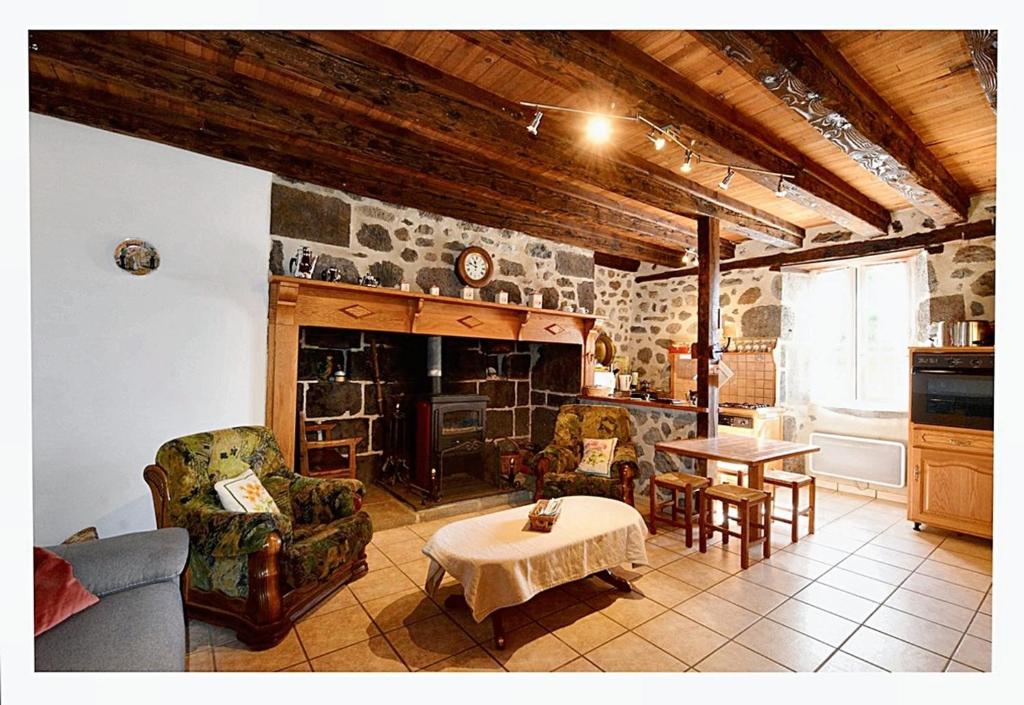 a living room with a fireplace and a table at Maison de 2 chambres avec jardin clos a Le Fau 