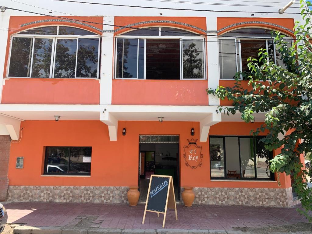 un edificio naranja con un letrero delante de él en HOSTAL EL REY en Cafayate