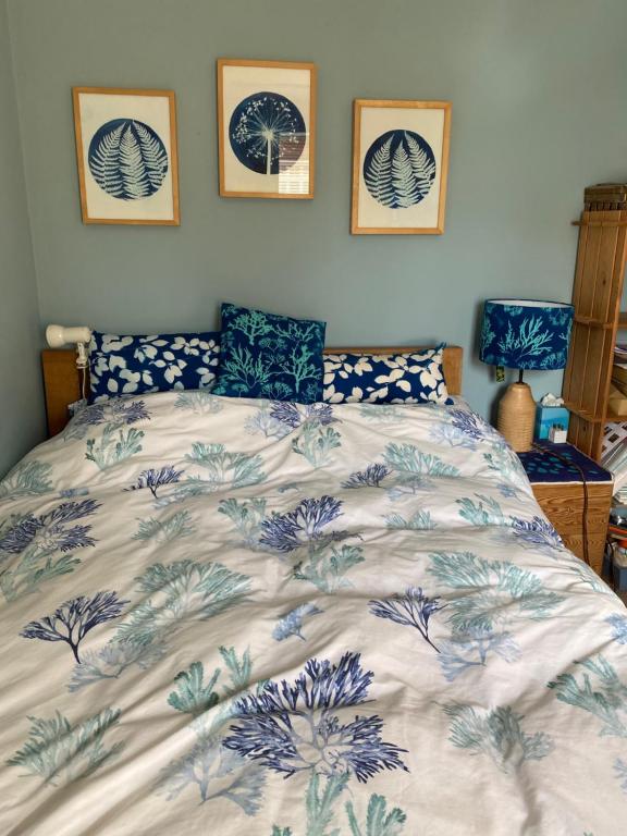 sypialnia z łóżkiem z niebiesko-białą kołdrą w obiekcie Shaptor Studio w mieście Bovey Tracey