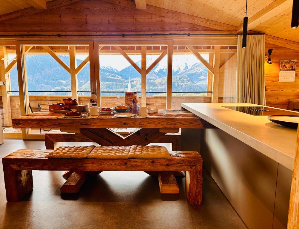 a wooden table and bench in a kitchen with a large window at Casa Felice in Trin