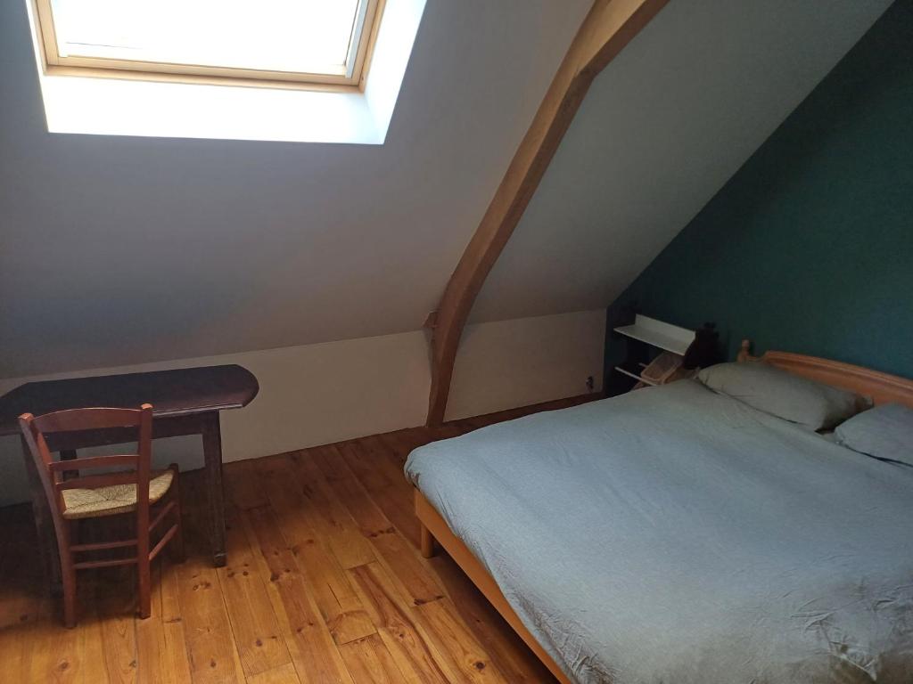 1 dormitorio con cama, escritorio y ventana en Chambre double à la campagne en Verchin