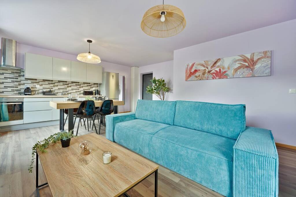 sala de estar con sofá azul y mesa en Purple House, en Vigneux-sur-Seine