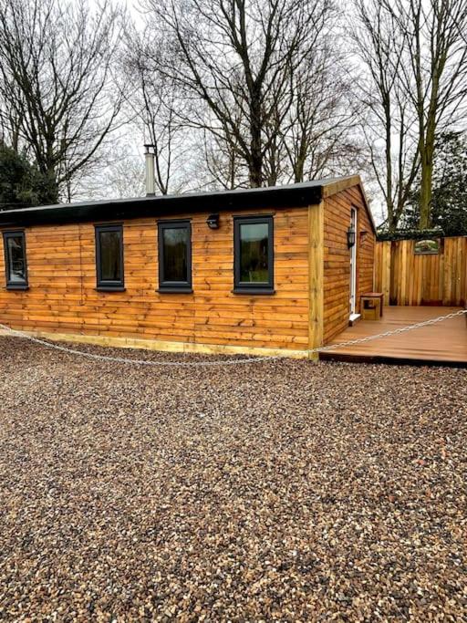 uma pequena cabana de madeira com um telhado sobre muito em old cricket pavilion, Riding mill, Northumberland em Newcastle upon Tyne