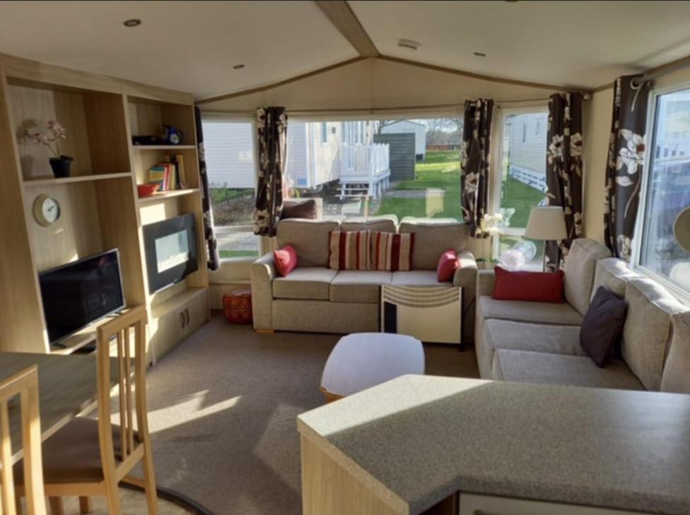 a living room with a couch and a tv at Hidden Gem Wilksworth Caravan Park Rural and Peaceful Setting in Wimborne Minster