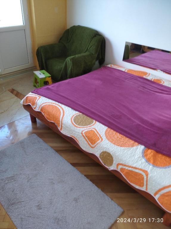 盧戈日的住宿－inchiriez 2 camere in apartament de 3 camere，紫色毯子的房间里一张床位