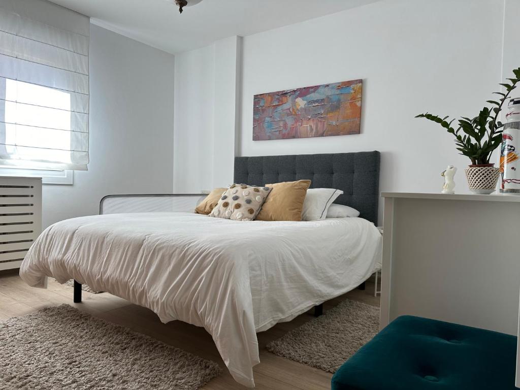 Dormitorio blanco con cama con almohadas en Apartamento Portonovo centro, en Portonovo